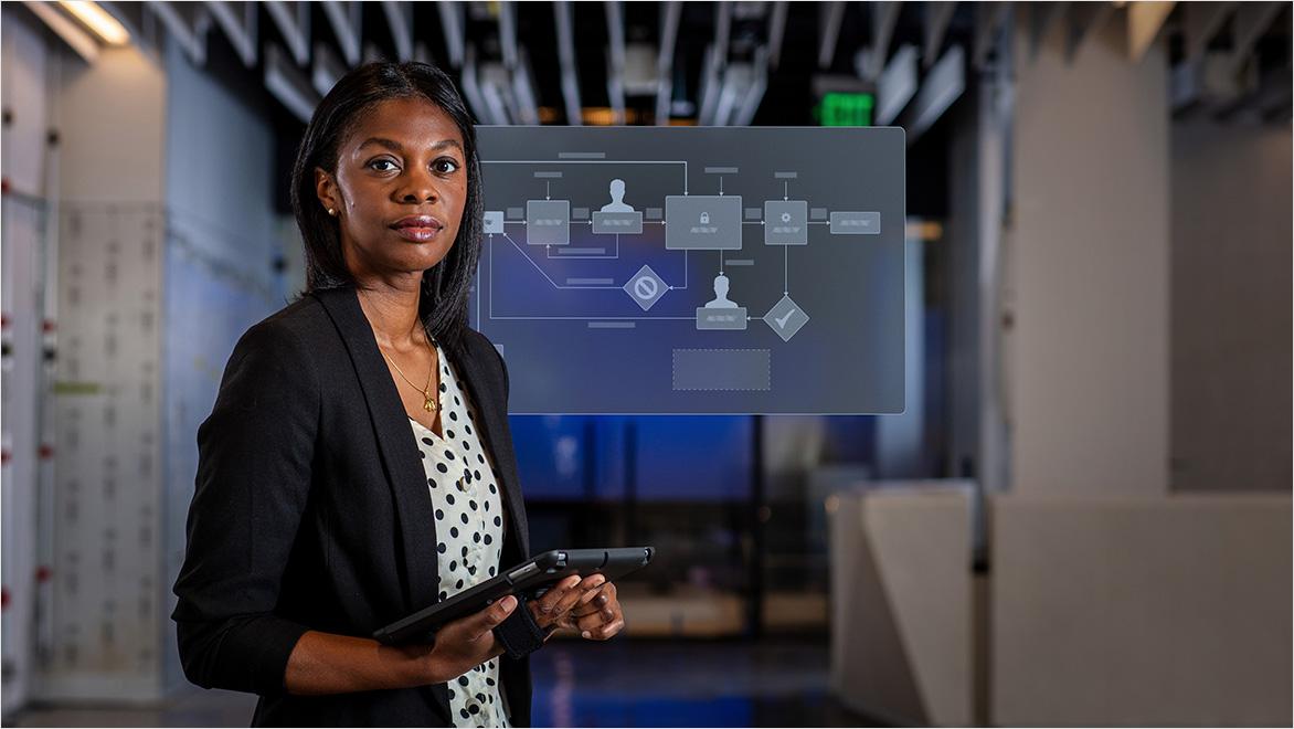 Manager holding tablet with change management workflow displayed on screen behind her