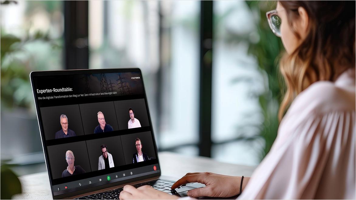 Eine Frau sitzt an einem Laptop und sieht sich ein Online-Webinar an.