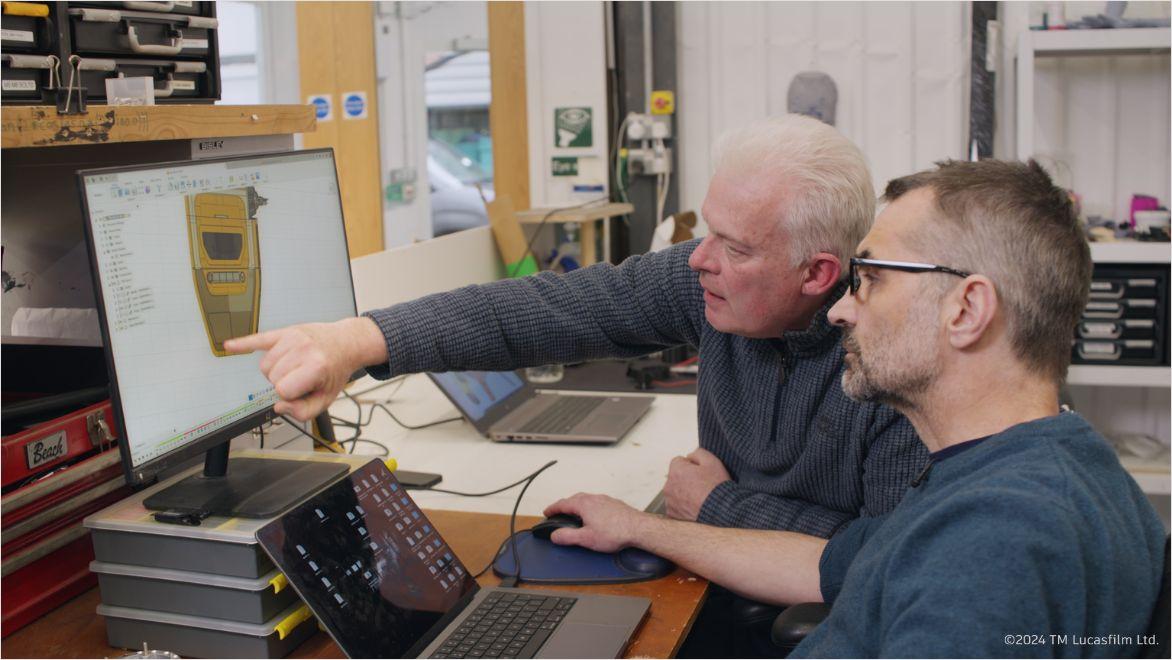 Neal Scanlan pointing at droid shown in Fusion on computer screen