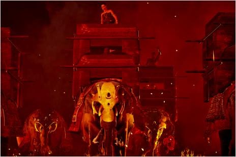 a person riding on top of a carriage on a elephant in armour