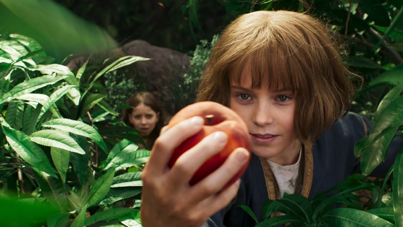 Young Furiosa holding an apple from Furiosa: A Mad Max Saga movie