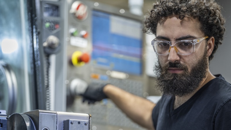 Image showcasing a worker on the manufacturing floor exhibiting Fusion Operations production data.