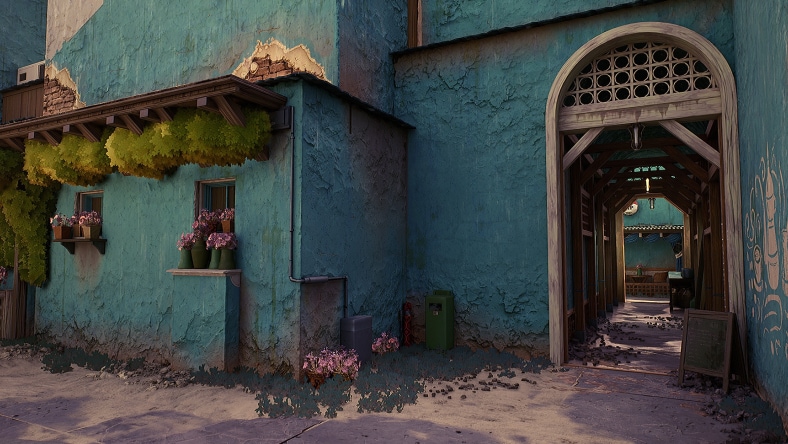 Rustic blue stucco house with hanging plants and an outdoor corridor