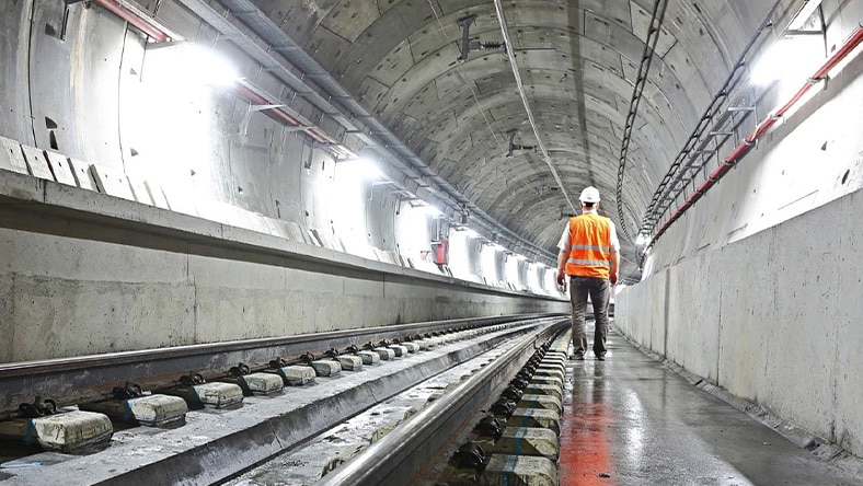Illustration of engineers of record discussing a project, with one reviewing a digital model on a tablet while the other examines plans, set in a design office environment.