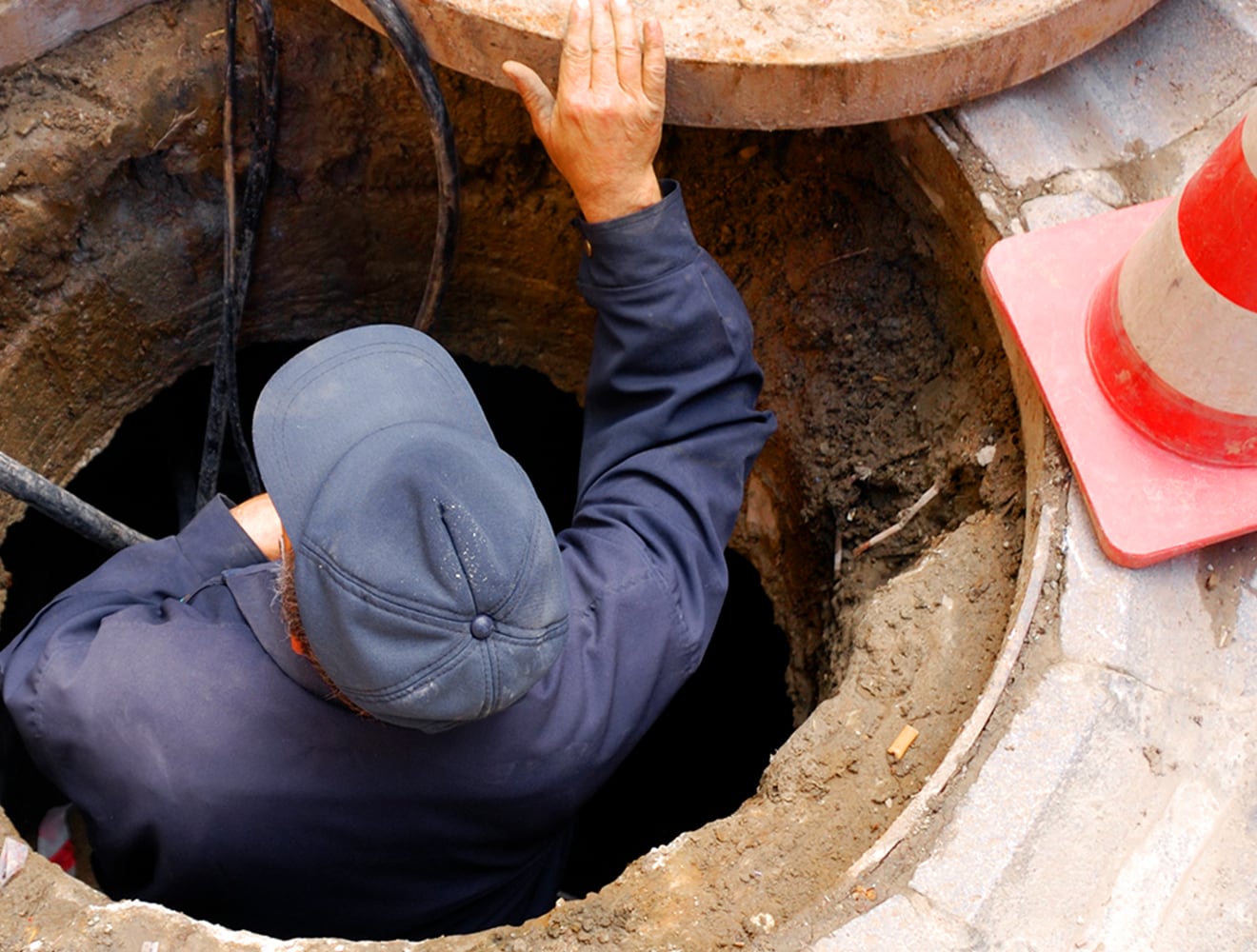Engineer descending into a wastewater pipe to carry out maintenance