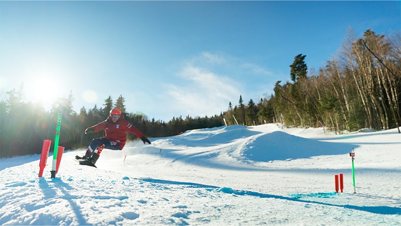 Mike Schultz skateboards on a snowy mountain course.