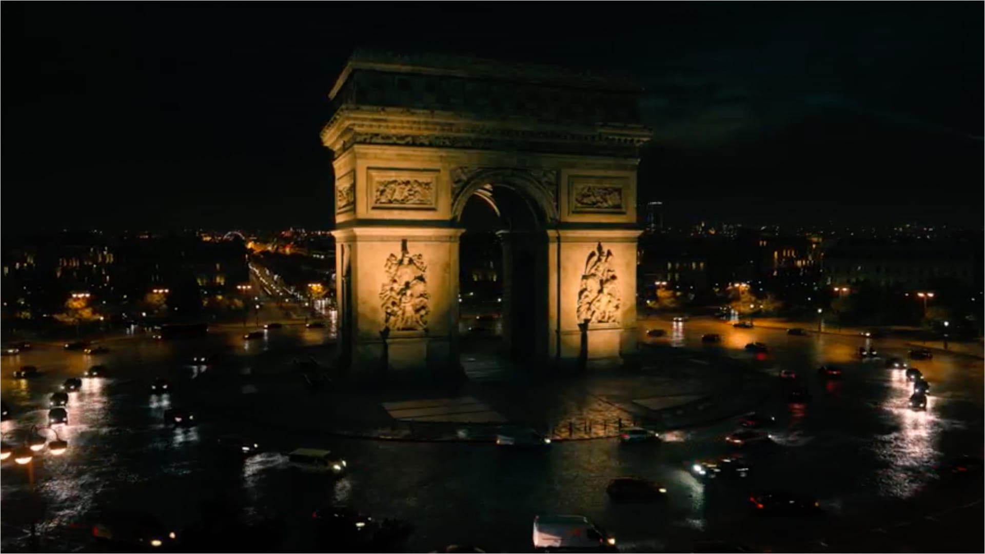 Cars driving around a monument.