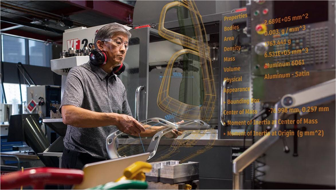 Man working with CNC machinery using Autodesk Fusion.