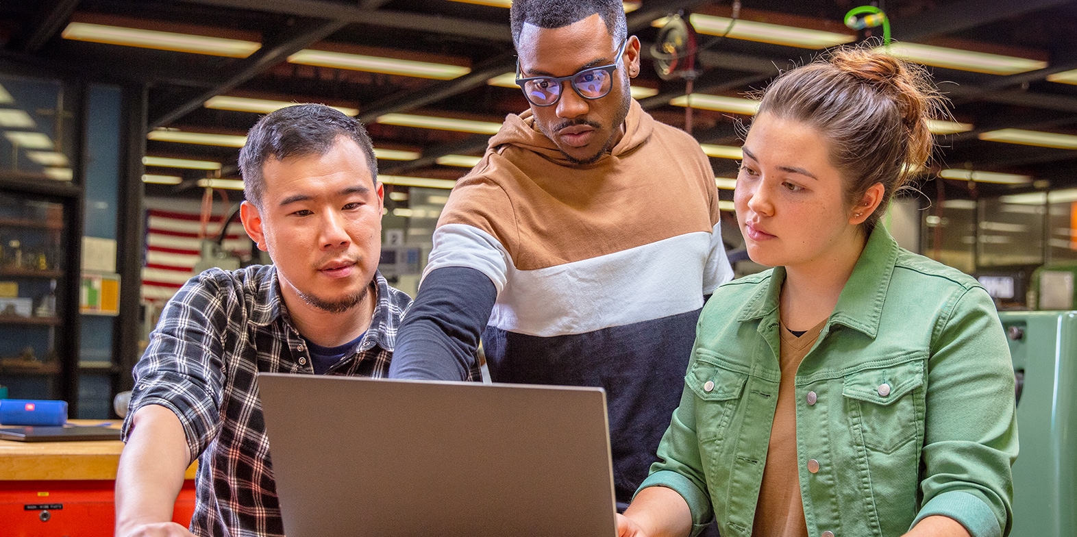 Three people looking at a laptop