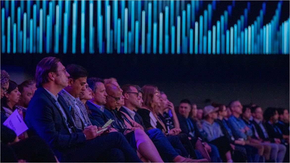 Business people sitting in a large room observing something