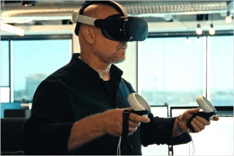 Man wearing VR headset and holding controllers in his hands