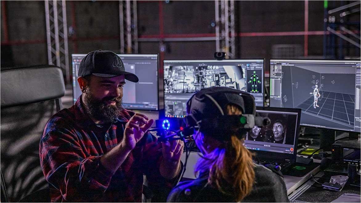 Technician setting up motion capture in VFX studio with Autodesk software.