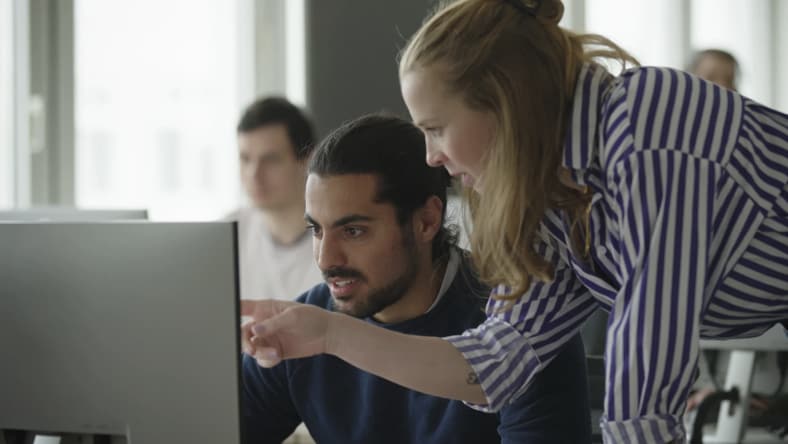 Teacher helping student in a computer lab