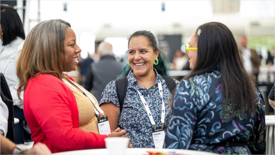 Three women smiling during a discussion