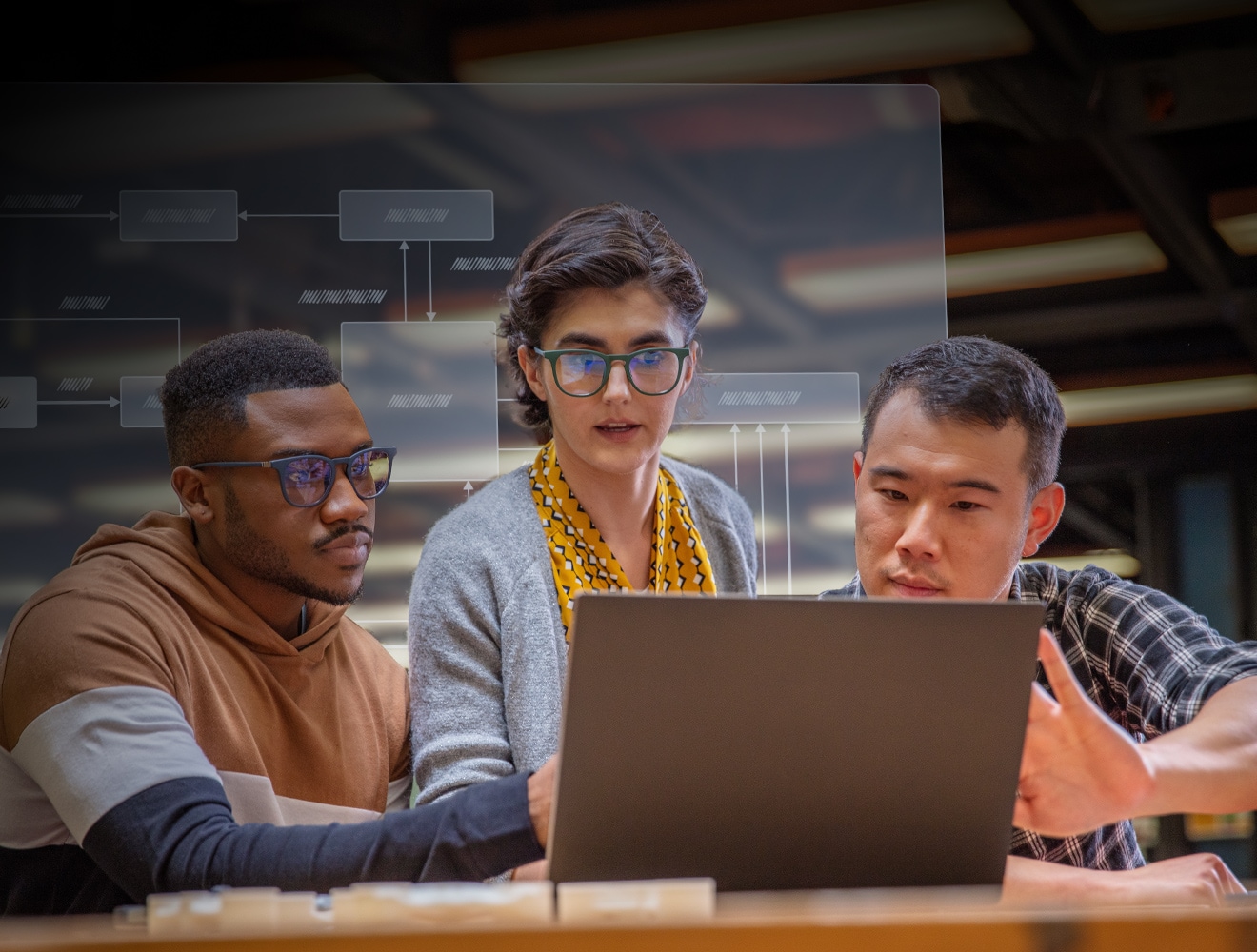 Three individuals gathered around a laptop, intently observing the screen together.