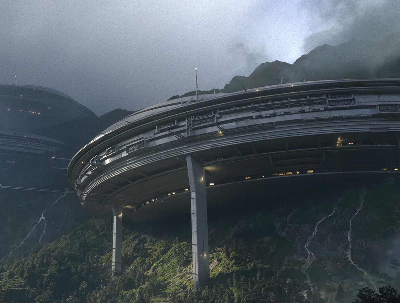 A modern, minimalist structure surrounded by desert vegetation and rocky terrain.