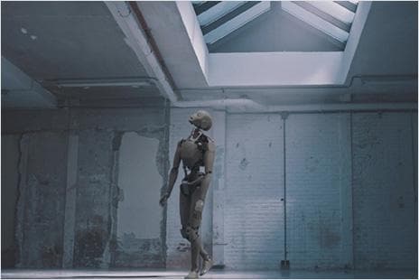 Humanoid robot standing in an industrial, minimalist setting