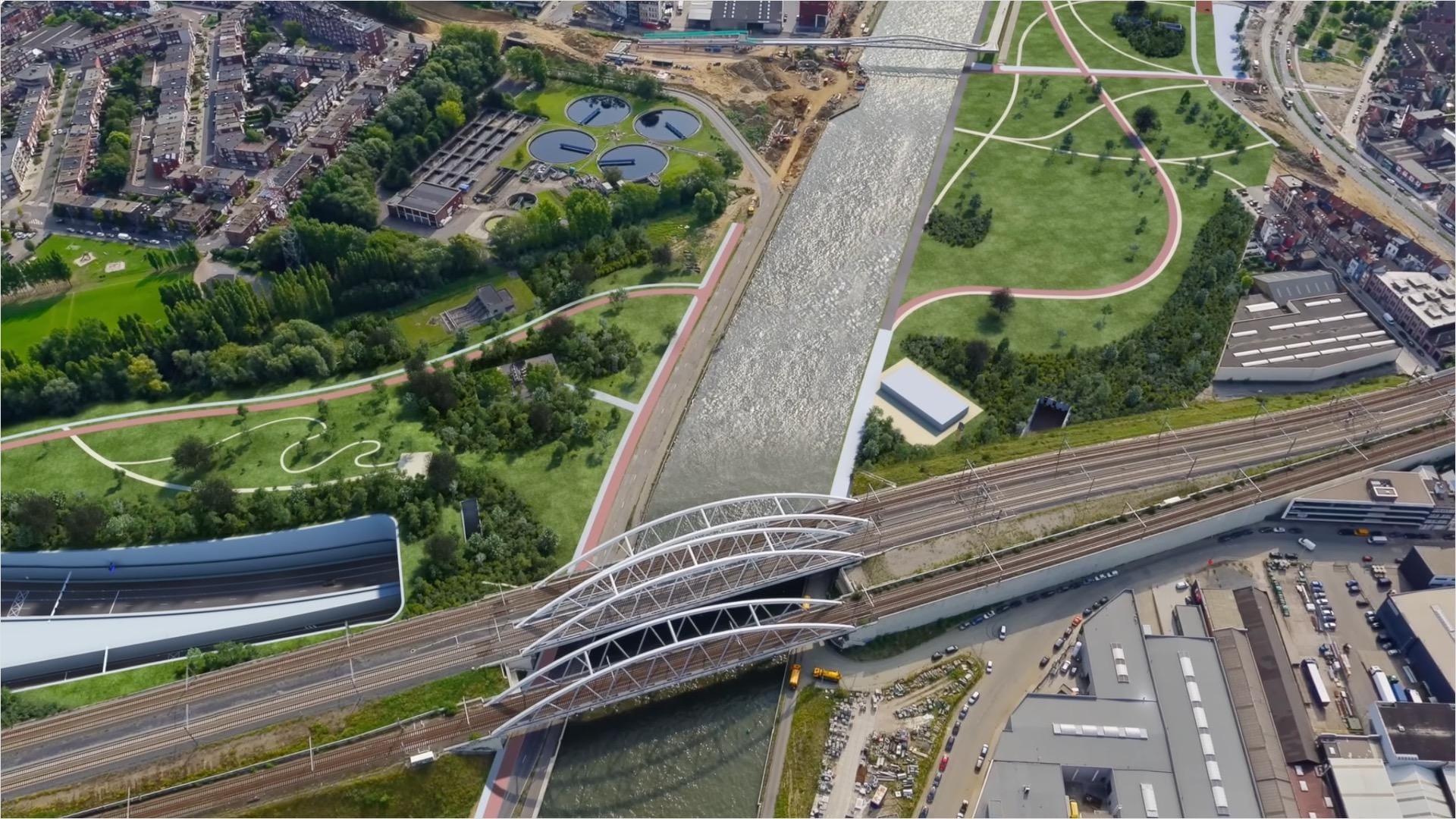 Aerial view of city infrastructure, including bridges, a canal waterway, roadways, grassy tree-lined parks, pathways, and housing developments, and industrial areas