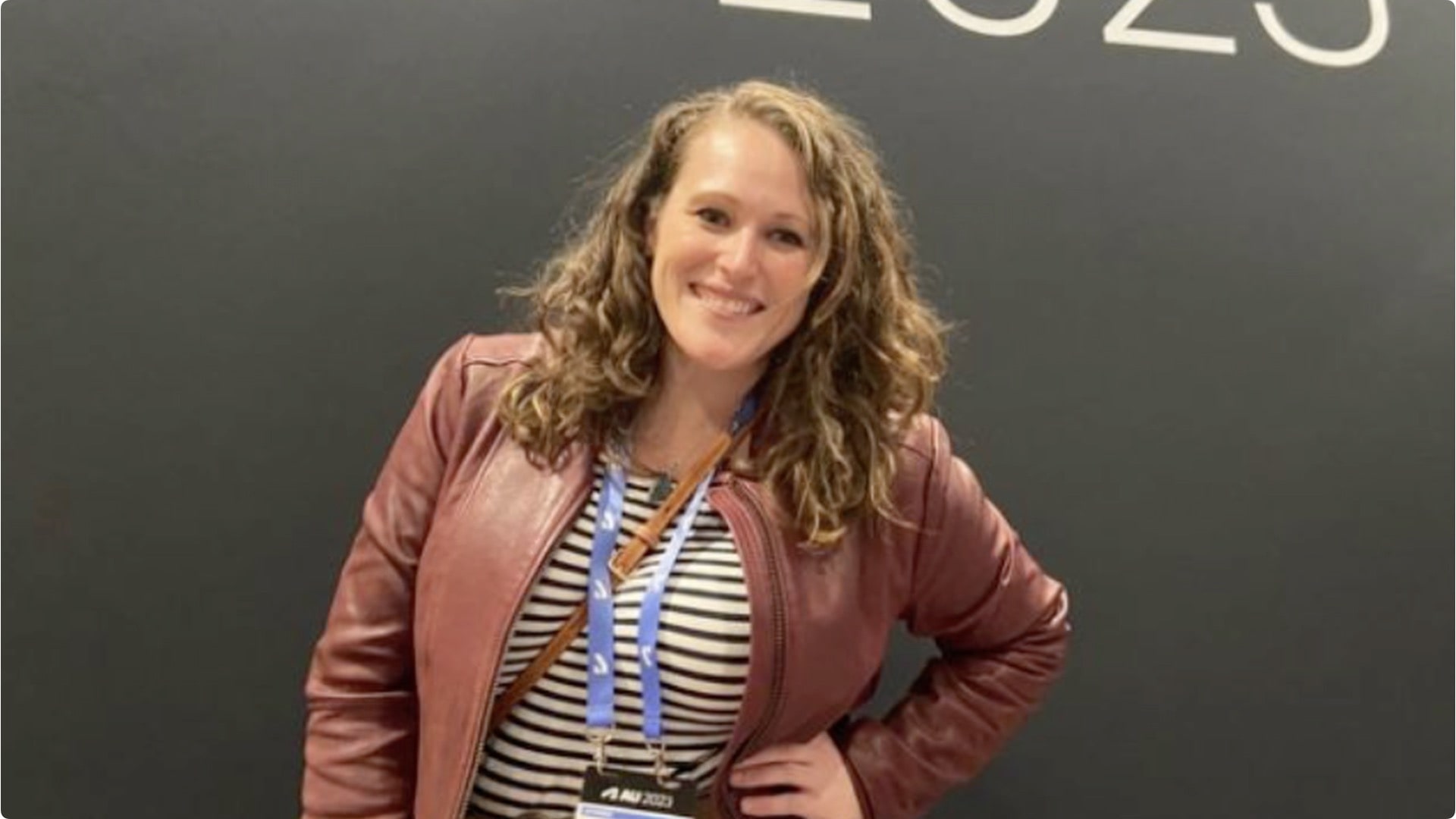 Public speaker and Civil 3D expert Shelby L. Smith in from of an Autodesk University graphic wall