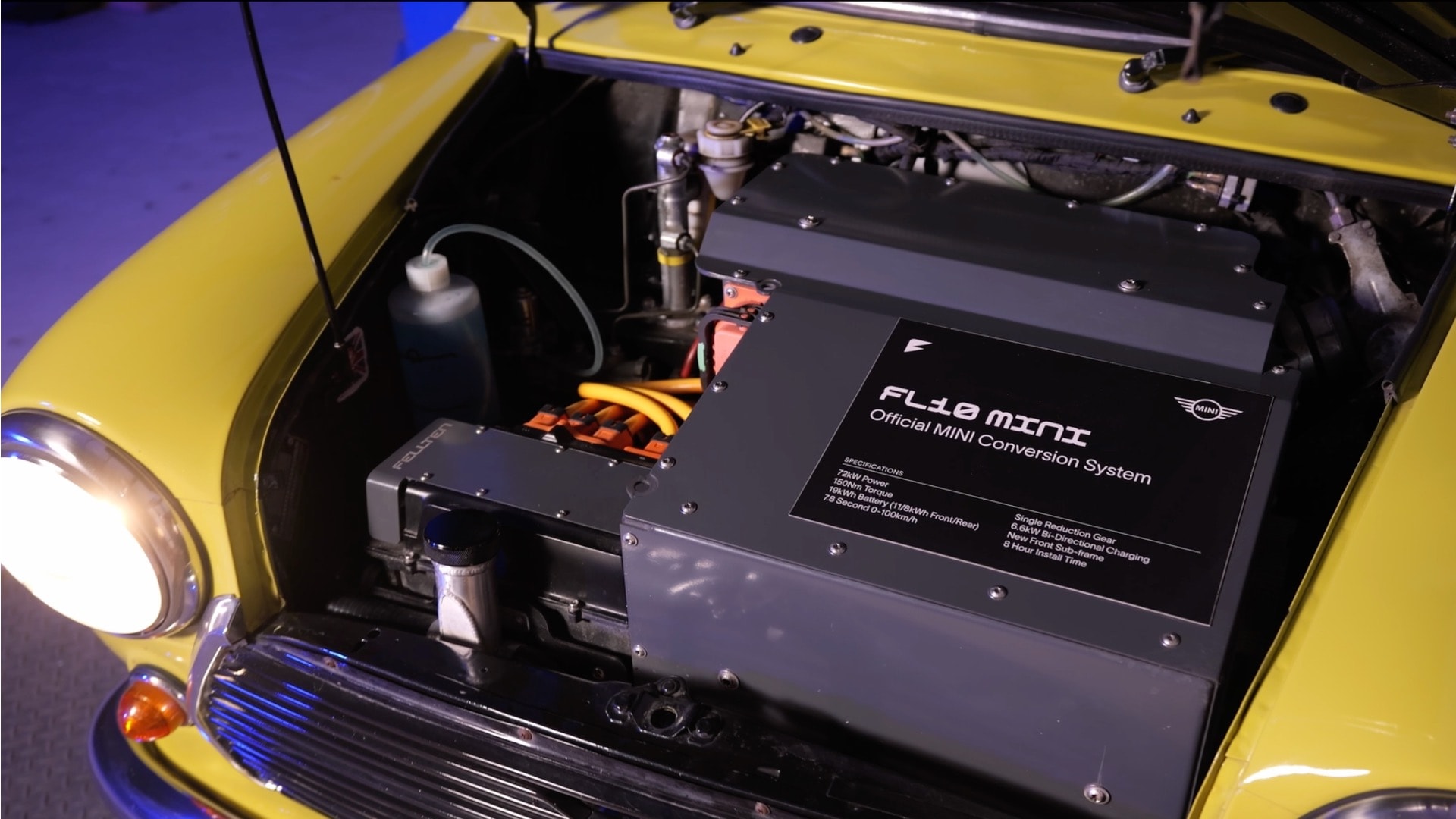 View into the front engine compartment of a vintage MINI showing an installed electric conversion kit