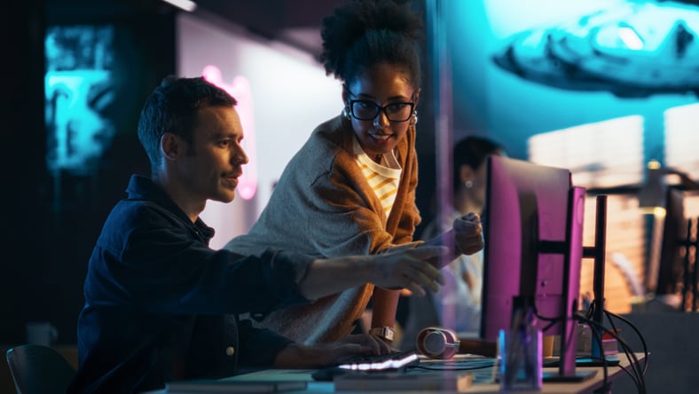 Two people reviewing content on computer screen