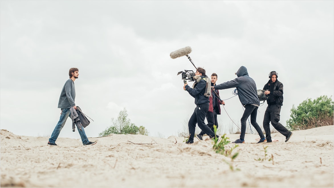 Film crew capturing man walking
