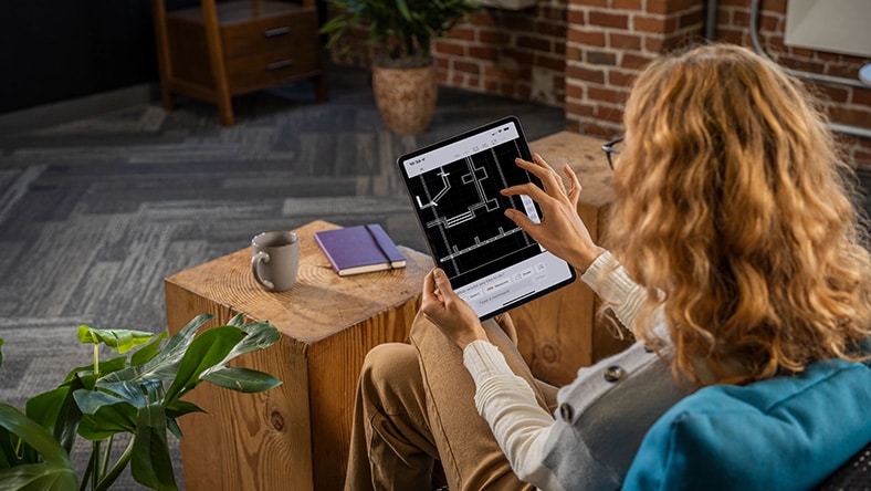 Woman using AutoCAD in a home office environment.