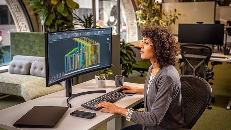 Woman using AutoCAD in an office environment.