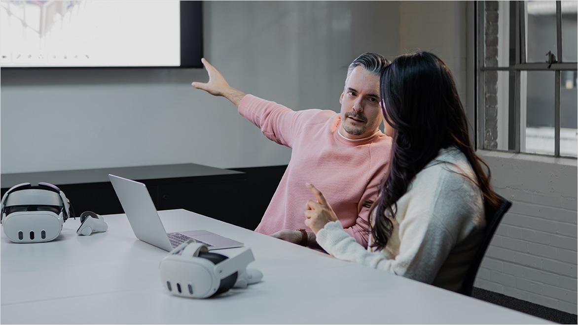 Two people working on computer looking at dataset
