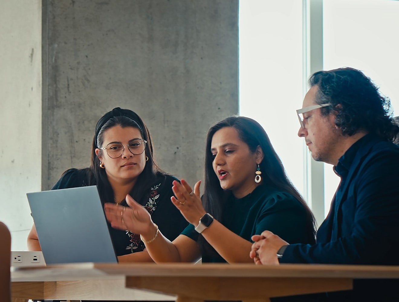 Image of three colleagues looking at a computer screen 