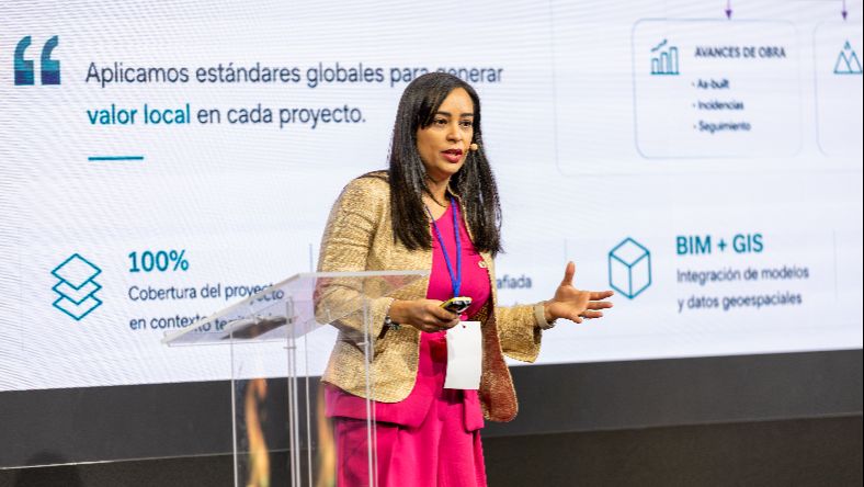 Ponente presentando en un escenario durante una conferencia.
