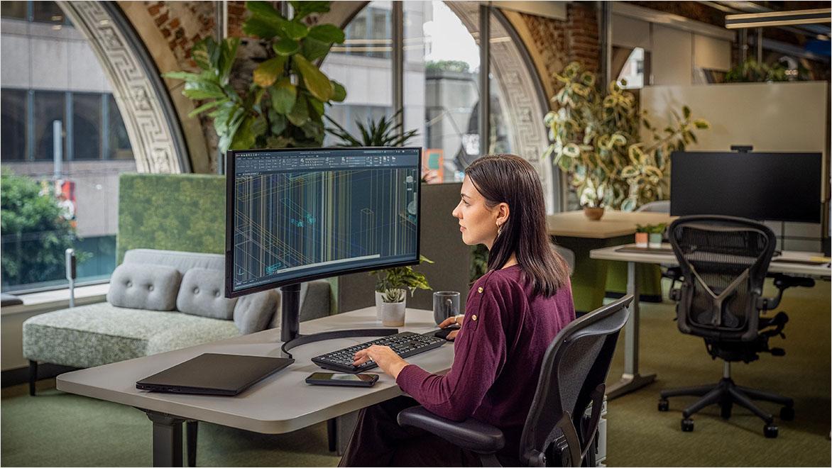 Woman using AutoCAD in an office environment.