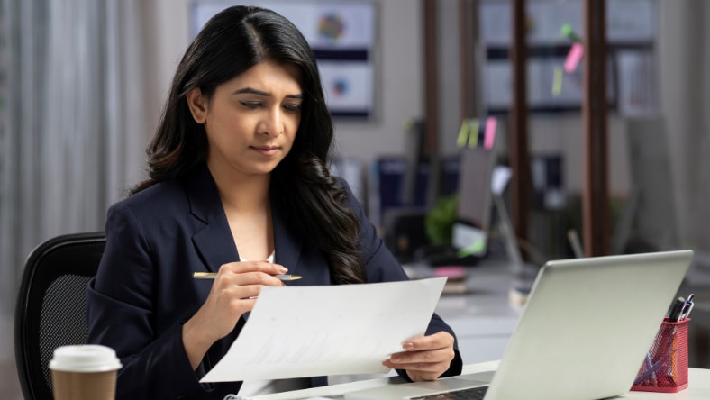 Woman with pen in hand and working in office