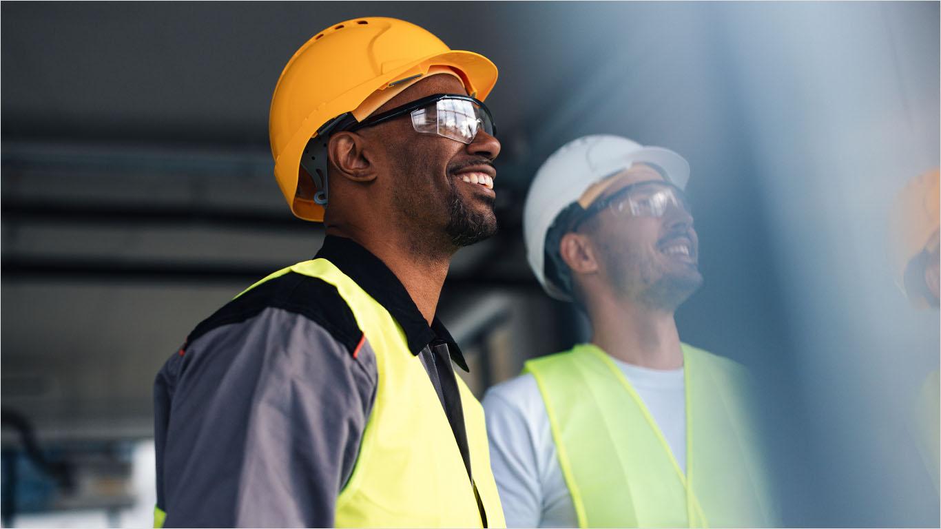 Two construction professionals review progress at an industrialized construction facility.