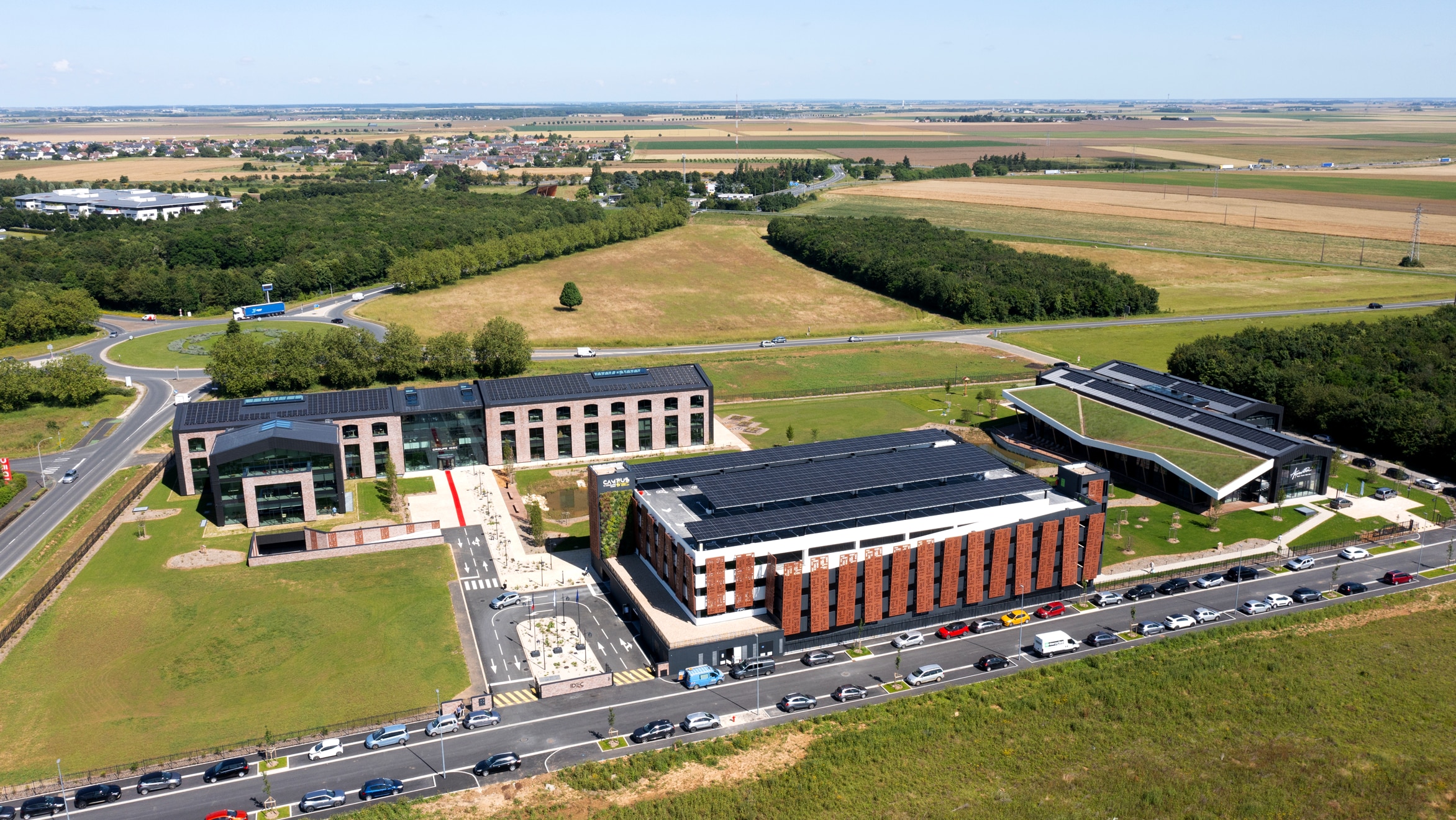 Vue aérienne du Campus IDEC avec le siège en fond, le parking Silo au premier plan et le centre de remise en forme à gauche - Crédit image Groupe IDEC