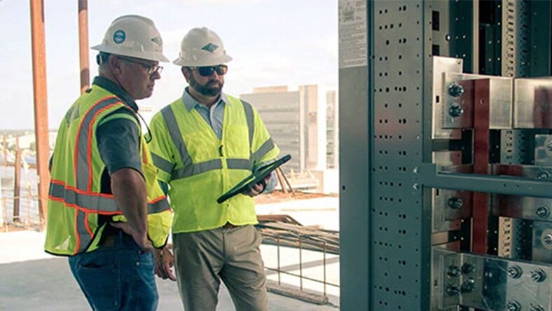 Workers viewing a digital tablet at a construction site