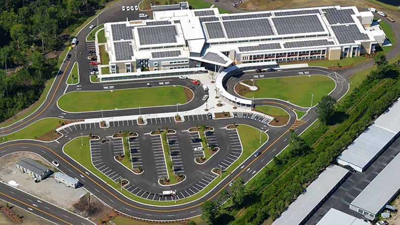 An overhead photograph shows a sustainable building campus and its parking lot.