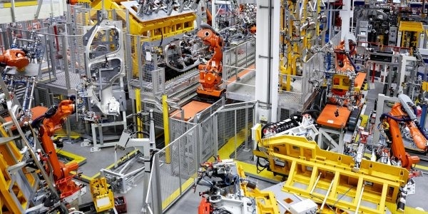 o这张照片显示了在一家汽车制造厂中使用的机械手臂。