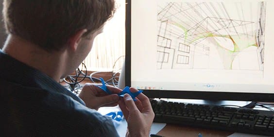 建筑师在电脑前拿着建筑模型图
