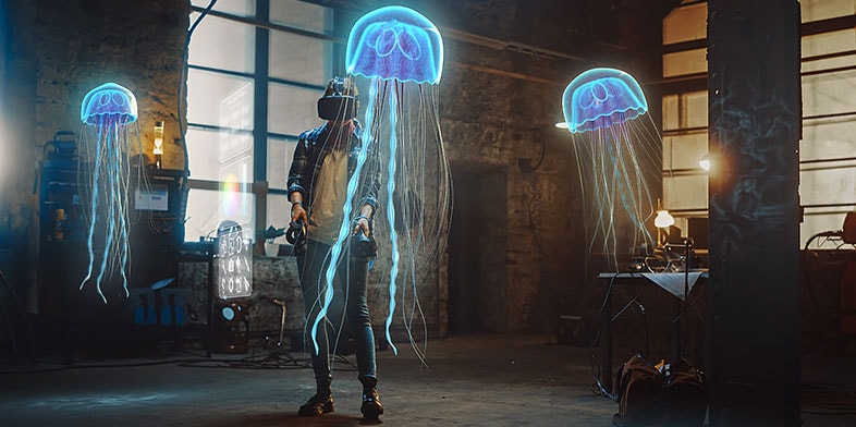Artiste portant un casque de réalité augmentée et manipulant des joysticks pour créer des sculptures abstraites de méduses en 3D 