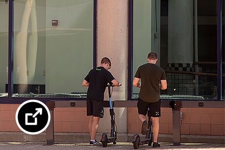 Two men getting ready to use scooters 