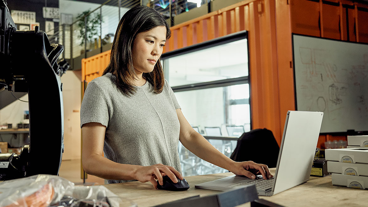 Mulher trabalha usando um laptop em um escritório