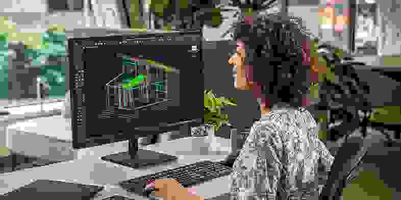Woman using AutoCAD software on desktop computer