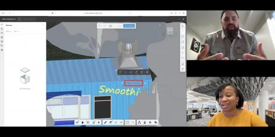 A split-screen video conference call between two people, with an application showcasing a 3D model interface in the background. The left side of the screen displays the interface of a design application, featuring a 3D model of a building façade with blue siding and the word "Smoothi" displayed in yellow text. There are various tools and icons at the bottom of the application window, indicative of design and editing functions. On the top right side of the image, a man with a beard is speaking, gesturing with his hands while seated in a room with white walls. On the bottom right, a woman with short hair, wearing an orange sweater, is smiling in an office setting filled with computers and bookshelves.