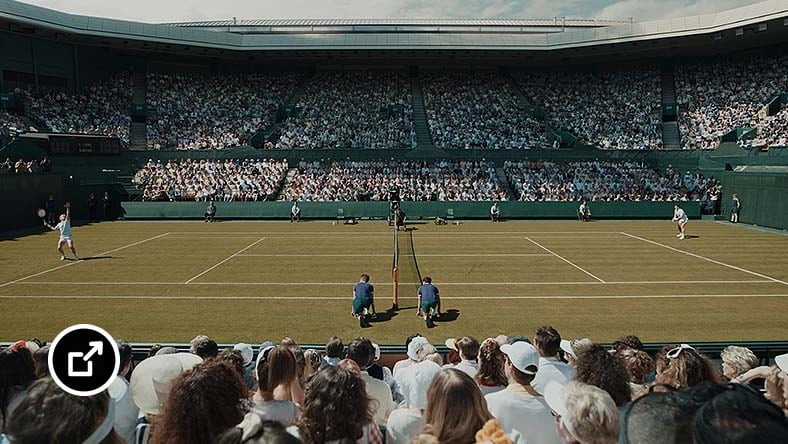 两名球员在座无虚席的体育场内进行网球比赛。