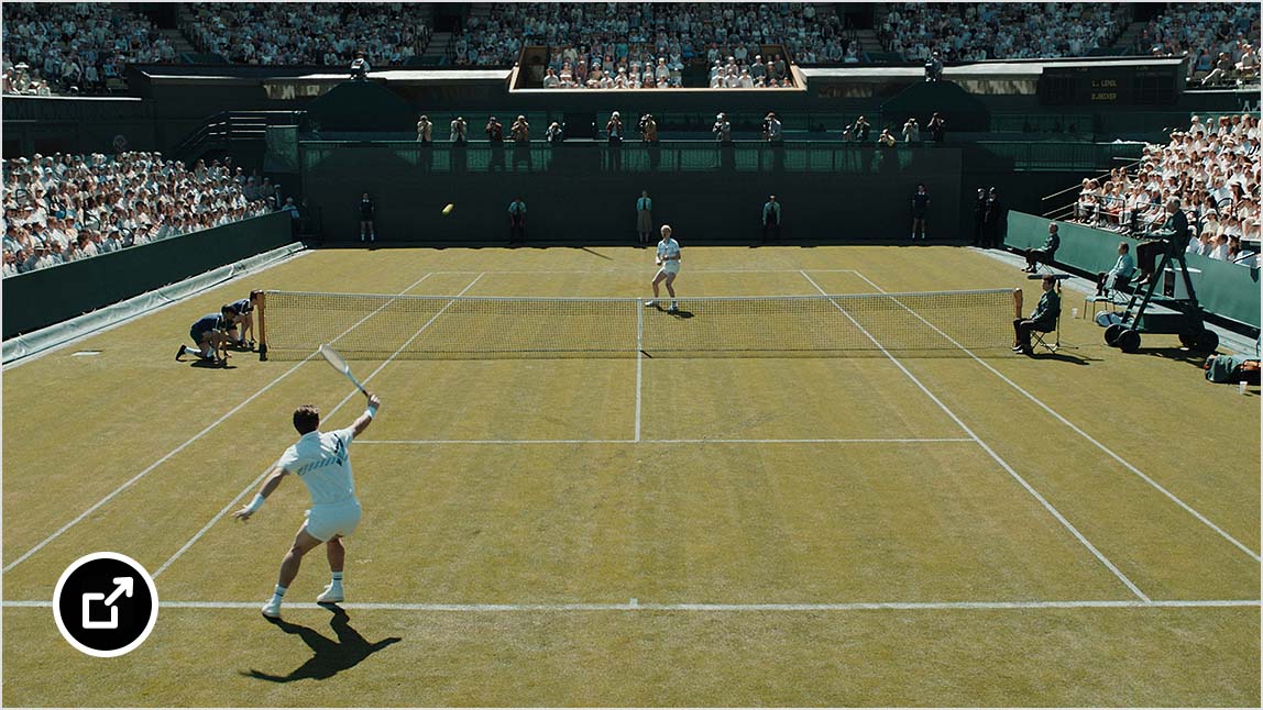 两名球员在座无虚席的体育场内进行网球比赛。