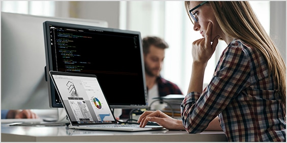 Woman working on laptop displaying spreadsheets