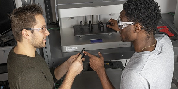 Zwei Personen bei einer Besichtigung der CNC-Maschinenhalle im Autodesk San Francisco Technology Center