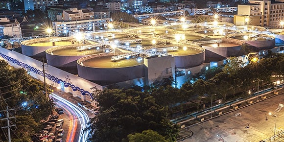 An aerial view of a water utility site lit up at night
