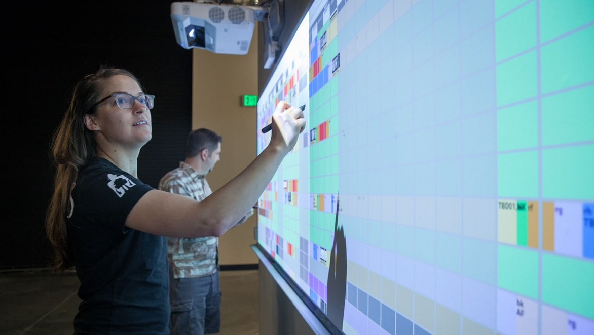LAIKA production staff members map out a film schedule on a giant wall-mounted screen